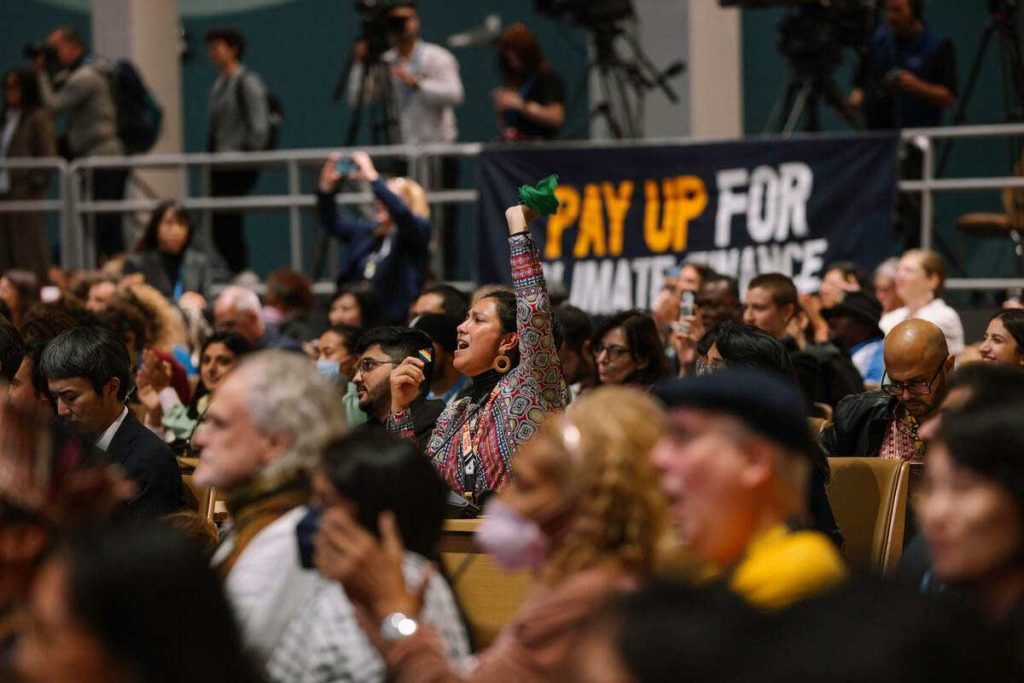 Activista levanta el brazo en señal de solidaridad en la sesión plenaria de los pueblos de la COP29 en Bakú, Azerbaiyán, noviembre de 2024.